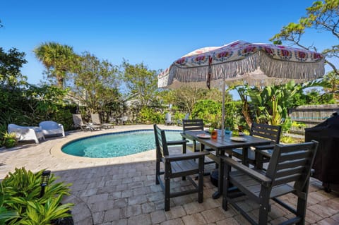 Outdoor Dining by the Pool
A shaded outdoor dining setup overlooking the pool, complete with colorful table settings and a decorative umbrella. Surrounded by tropical greenery, it’s the perfect spot for meals or cocktails in the sunshine.