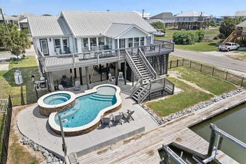 Elevated coastal home with private pool, hot tub, and waterfront dock in peaceful residential area.
