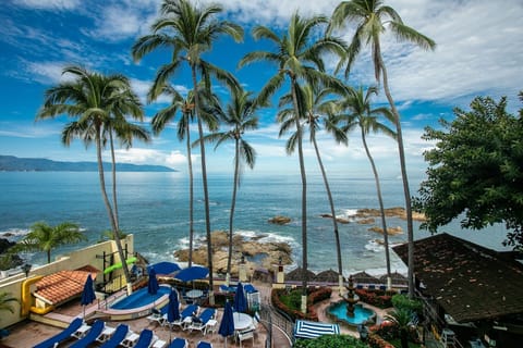 Experience stunning oceanfront views framed by lush palm trees, inviting you to relax and enjoy the beauty of Puerto Vallarta.
