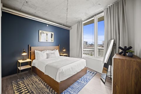 Wake up refreshed in a sunlit bedroom with skyline views.