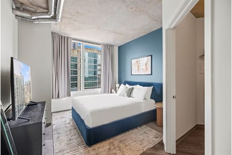 Unwind in a serene bedroom with crisp linens and city views.