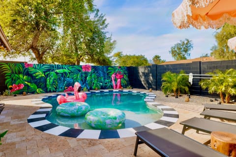 Resort-style backyard pool with tropical mural and chic lounge seating