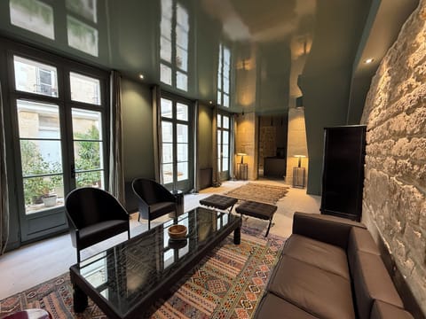 Living room, ,stone wall and floors, 1ft high windows, Moroccan carpets 