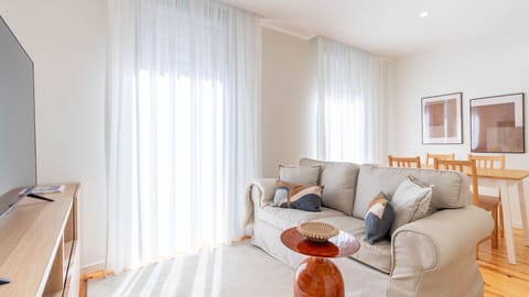 Sunlit living area with cozy sofa and dining space #BrightSpaces #PortoLiving