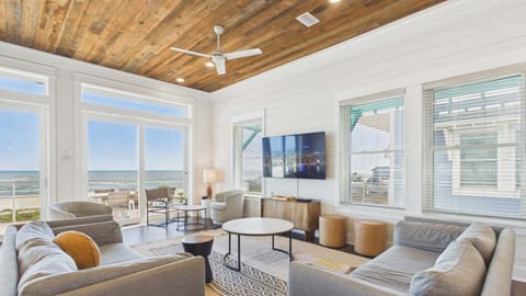 2nd Floor: Open concept living area with stylish furnishings and huge TV while providing balcony access