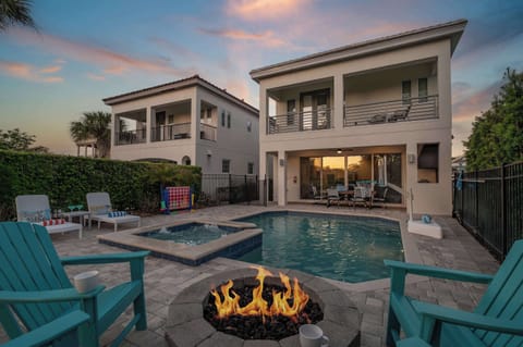 Unwind by the glowing firepit beside the pool in this beautifully lit backyard retreat