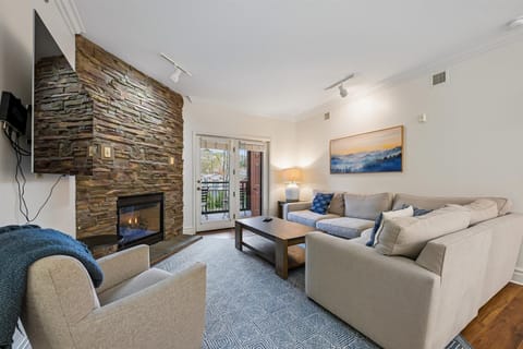 Cozy up in your spacious living room where a stone fireplace creates warmth while you relax on plush seating.