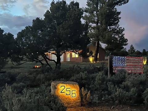 A magical dusk scene with lit address marker, glowing flag, and crackling fire. 