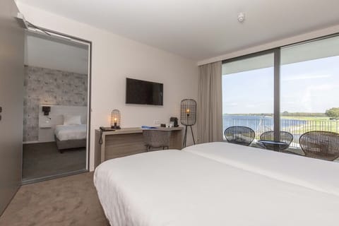 Wake up to serene water views from a plush bed.