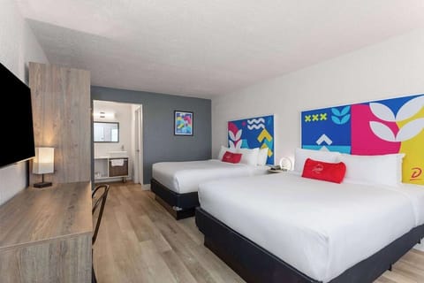 Settle into bright comfort with two plush beds and TV.