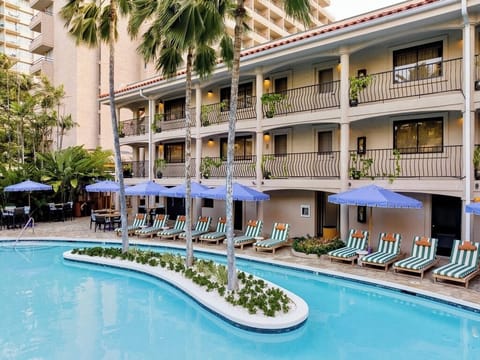 Lounge poolside with shaded chairs and breezy tropical calm