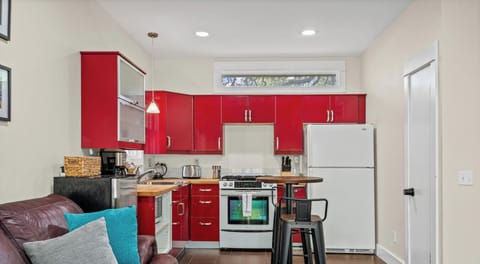 Brew your morning coffee or prep a full meal in this fully stocked kitchen. Bold red cabinets and butcher block counters add character.