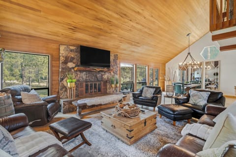 Sink into plush leather seating around your crackling stone fireplace, where warm wood ceilings create the perfect cozy retreat.