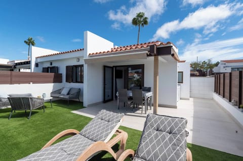 Private terrace with artificial grass, equipped with sun loungers, an armchair, and a table with chairs