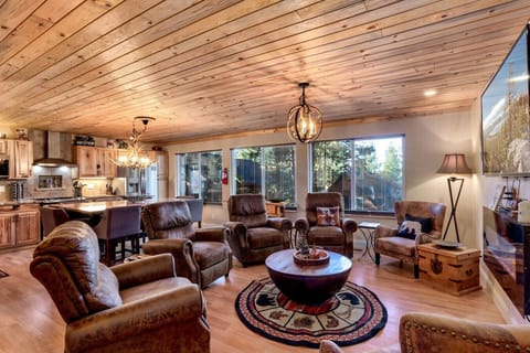 Bright living room with forest views, comfy chairs, and a warm cabin feel. A favorite spot for guests.