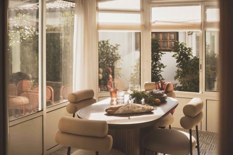 A sunlit dining nook framed by greenery—perfect for slow breakfasts and lively evening conversations.
