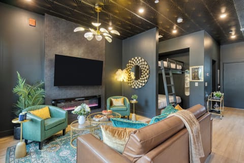 Unit 105: Modern studio with flat-screen TV and electric fireplace.