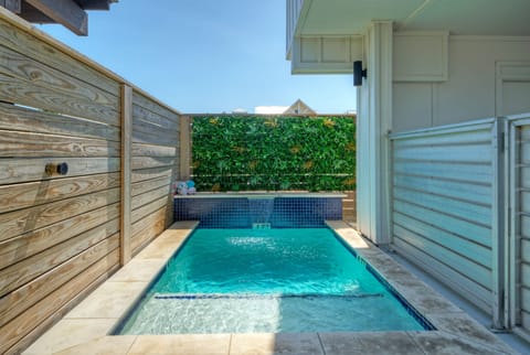 Serene private plunge pool with a soothing waterfall and lush greenery.