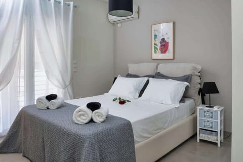 Serene bedroom with crisp white linens and soft lighting — your peaceful retreat in the heart of Athens