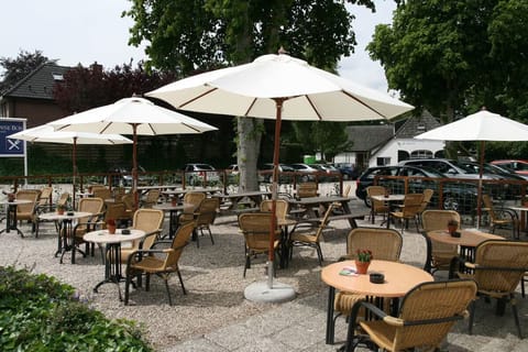Sip and relax outdoors under umbrellas on the sunny terrace.
