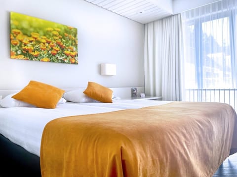 Unwind in a sunlit bed dressed in warm, cozy tones.