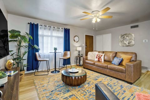 Welcome to Fairway Bungalow! The open living area welcomes you with warm wood flooring, a patterned area rug, and a plush brown sofa — a comfortable, well-styled space designed for relaxing between Colorado Springs adventures.