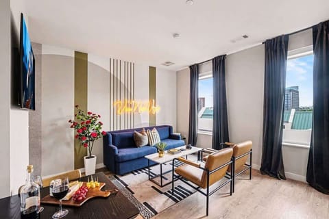 Bright and open living area featuring a smart TV and plush furnishings. Connects to the dining area and kitchen.