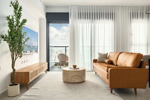 Sunlit living area opens to private balcony, blending relaxed comfort with elevated cityscape atmosphere effortlessly.
