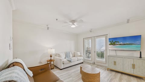 Open concept living area with stylish furnishings, sleeper sofa, and direct access to balcony + gulf views