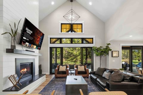 Main floor living — leather couch, 72" Smart TV & shiplap gas fireplace s