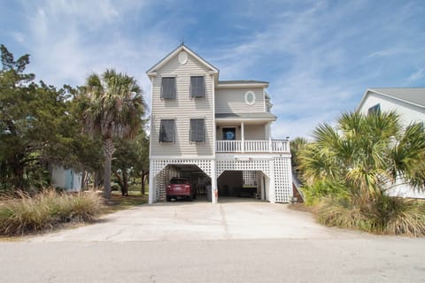 Charming coastal home with elevated design, covered parking, and tropical landscaping in a peaceful neighborhood setting.