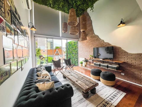 [Living Room] Soaring two-story windows + electric curtains flood the living room with natural light and epic Buenos Aires views. Seamless flow to the expansive balcony for effortless indoor-outdoor living.