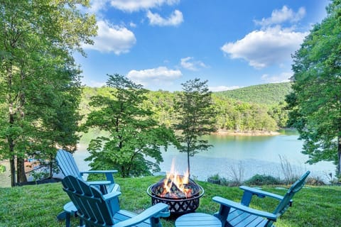 Fire pit overlooking the lake and dock with Andirondack chairs and tables