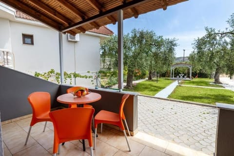 Covered patio with an outdoor table and chairs, opening directly onto the garden. A shaded, ground-floor space that gives you easy access to the outdoors throughout the day.