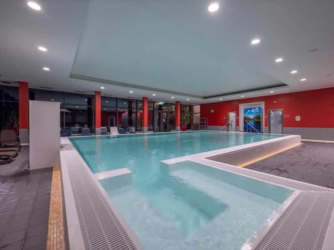 Unwind in the spacious indoor pool with calm lighting.