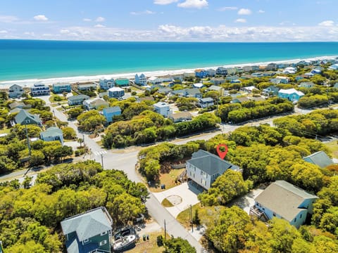 Aerial view of coastal vacation rental community with pristine turquoise waters and sandy beaches nearby.