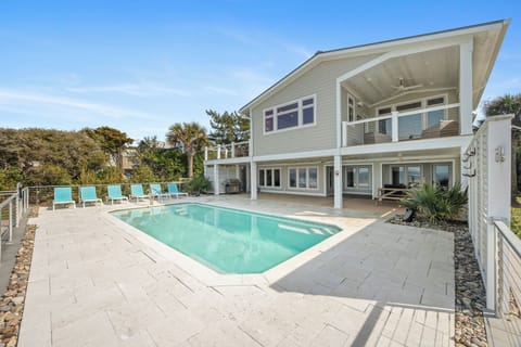 Modern coastal home with private swimming pool surrounded by tropical landscaping and spacious outdoor entertaining areas.