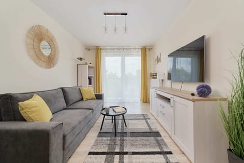 A cozy living room with a comfortable sofa, TV, and vibrant decor accents.

