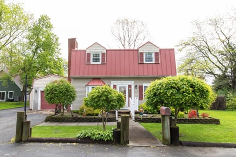 The property sits in a quiet residential area with mature trees, landscaped gardens, and convenient parking, offering a charming arrival experience in a peaceful neighborhood setting.