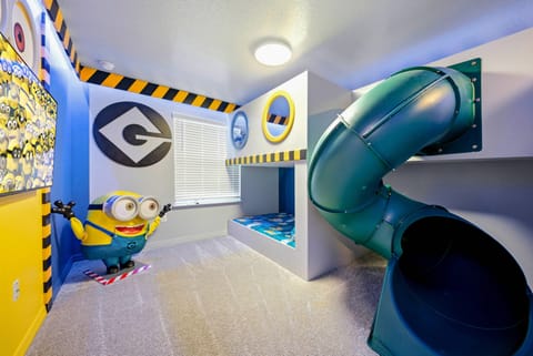 Welcome to a playful paradise with vibrant yellow and blue walls full of fun character art. Enjoy the thrilling slide that adds excitement, and relax on the plush carpet after your joyful descent.