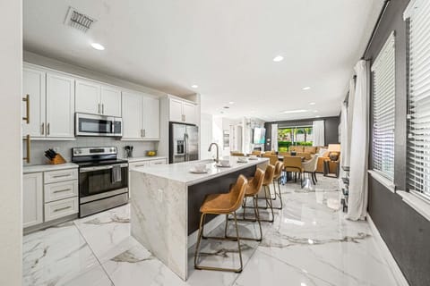 Cook & connect in a sleek kitchen w/ island seating, stainless appliances & open layout