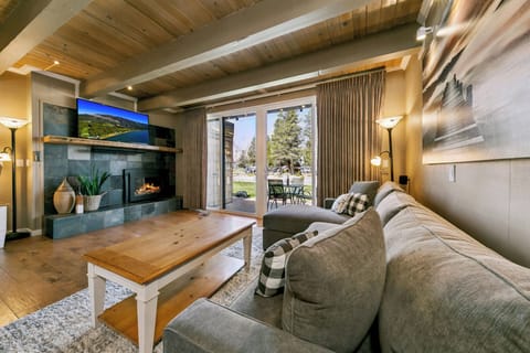 Unwind on the plush sofa in your cozy living room, where warm wood beams meet modern comfort. Your perfect retreat features a welcoming fireplace and opens to your private patio.