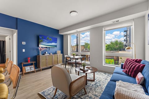 Your bright, open living space with stunning city views! Imagine sipping coffee at that perfect dining nook while watching the world wake up outside. Stylish blue accent wall and cozy seating - pure Minneapolis magic! ✨