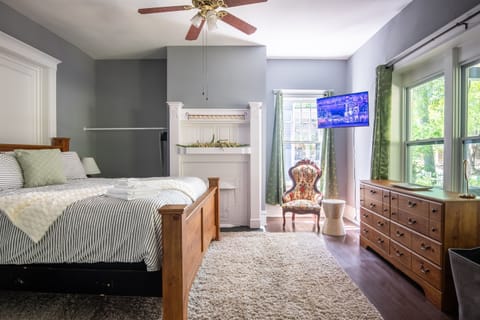 Continuing through the home, you’ll step into a cheerful guest room featuring a comfortable queen bed, TV for entertainment, and a dresser to keep your stay organized and relaxed.