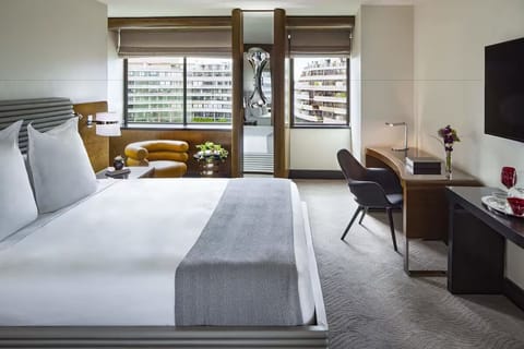 Unwind in a bright bedroom with skyline views and plush bedding.