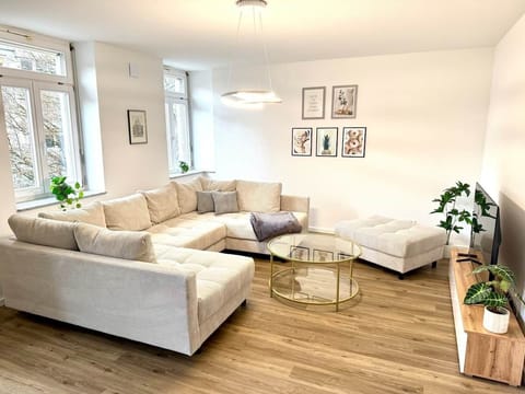 Das Wohnzimmer mit direktem Blick auf den Marienplatz. Das wunderschöne XXL Sofa lädt zu einer gemütlichen Runde ein. Also ein Ort zum Verweilen und Genießen.