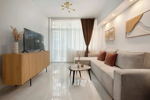Bright and comfortable living room with modern décor, a cozy sofa, TV, and a relaxing atmosphere. Perfect for unwinding after a busy day.

