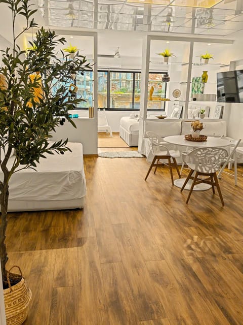 Bright and spacious living area with warm wooden floors, stylish décor, and large windows that fill the space with natural light—perfect for relaxing after a day of exploring.
