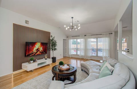 Airy, sunlit living room with plush seating and statement TV wall—perfect for movie nights and relaxing in style.