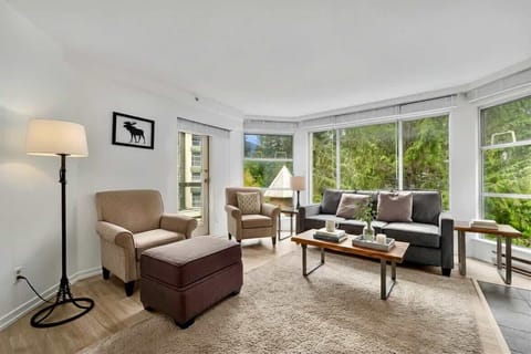 - Bright living room with mountain views and stone fireplace centrepiece - Plush seating, a sofa bed and flat-screen TV create a cozy modern feel - Ideal space to unwind after skiing or hiking adventures in Whistler